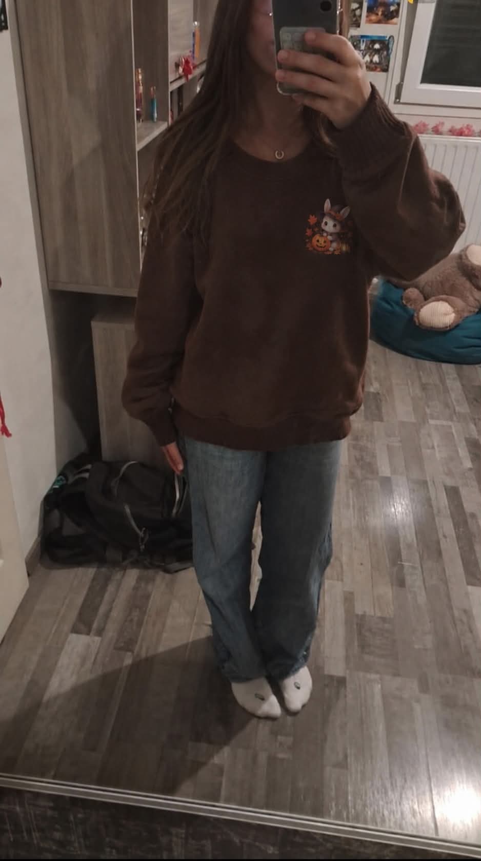 Selfie au miroir de face, sweat chocolat ample avec le petit lapin côté cœur, porté avec un jean.